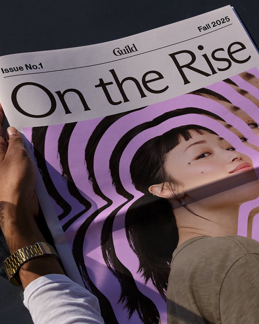 Hands holding a printed copy of the On The Rise newspaper